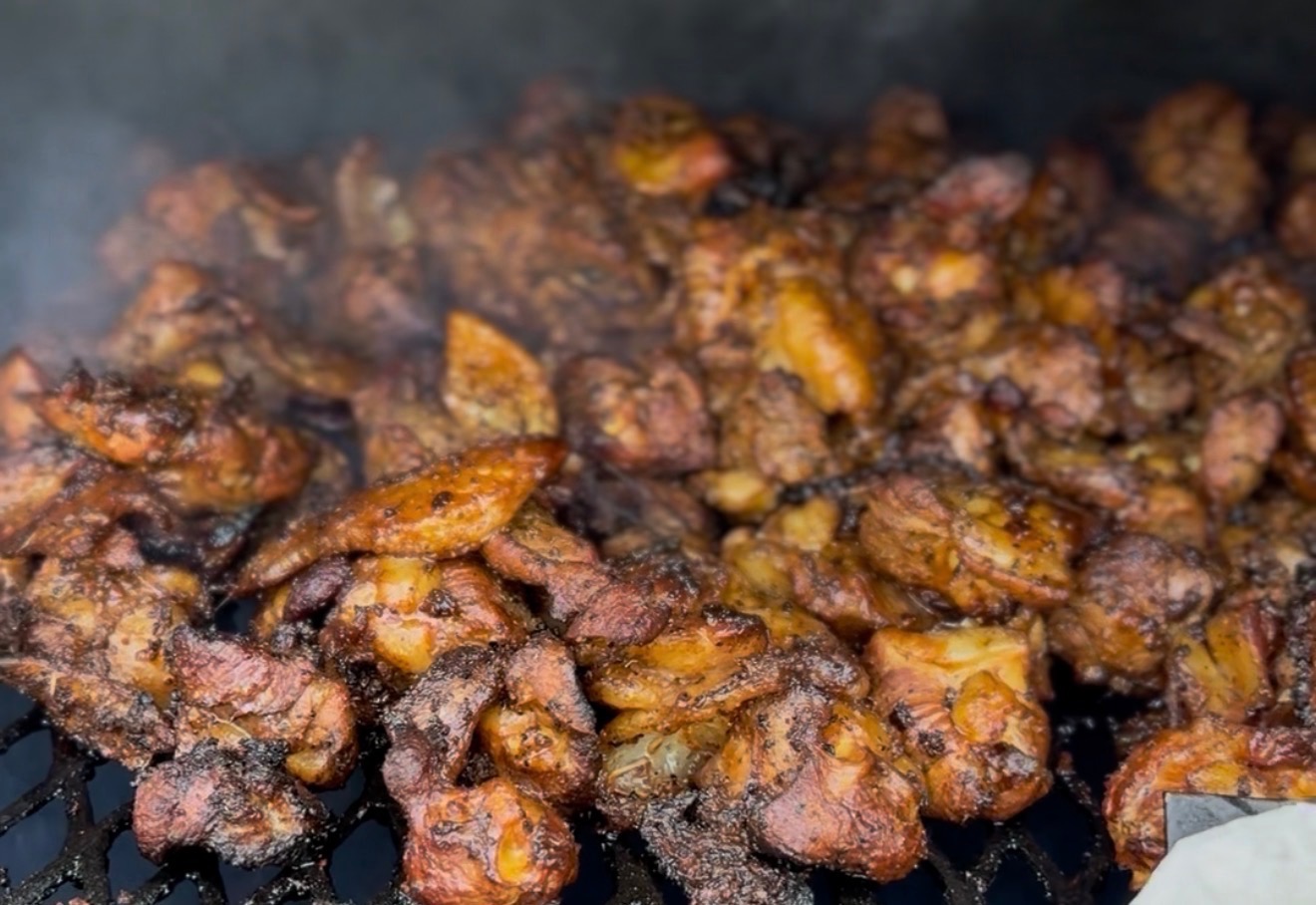 Whole smoked chicken resting on a carving board
